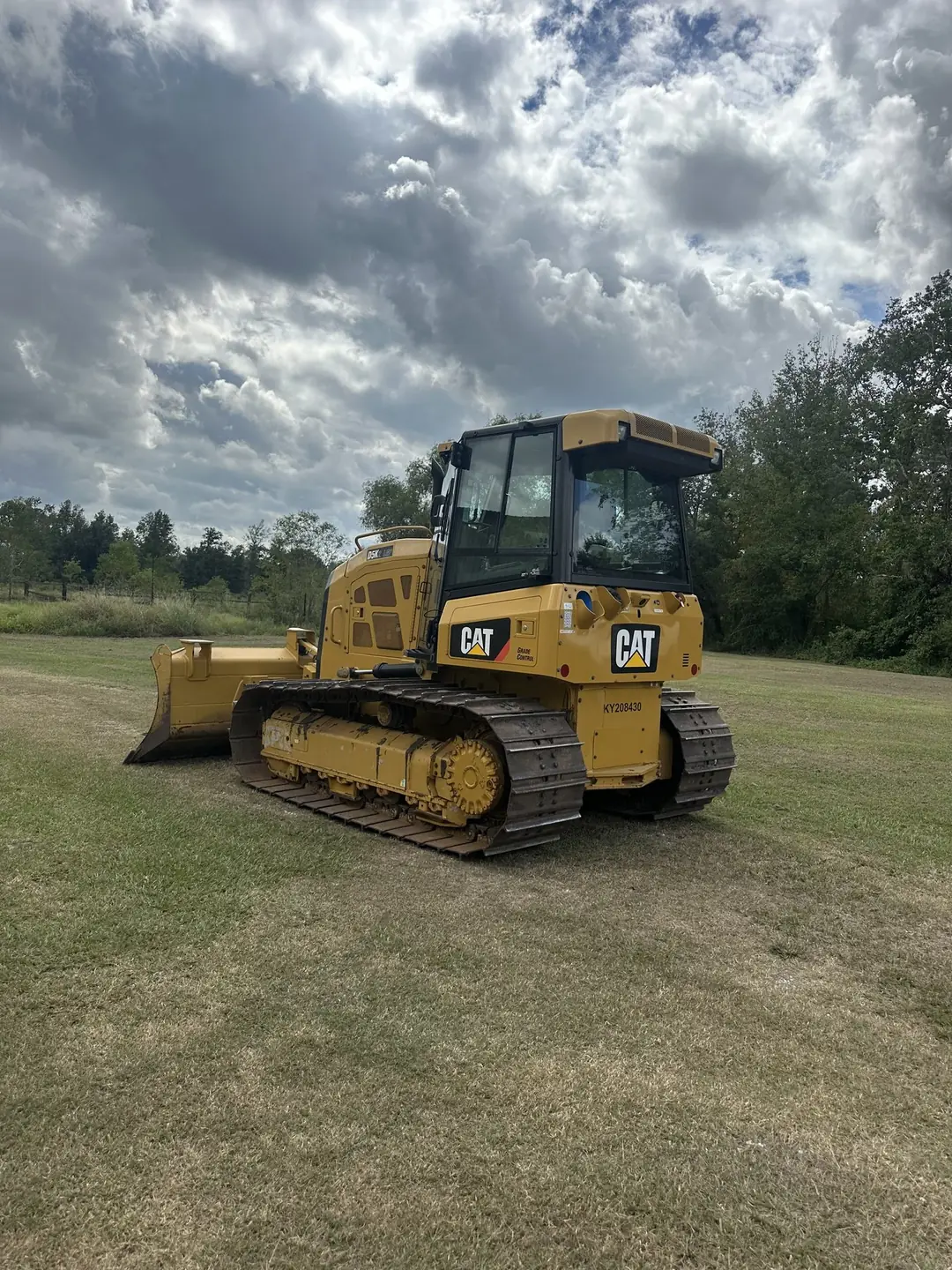 Tracked dozer with grade control staged in an open field