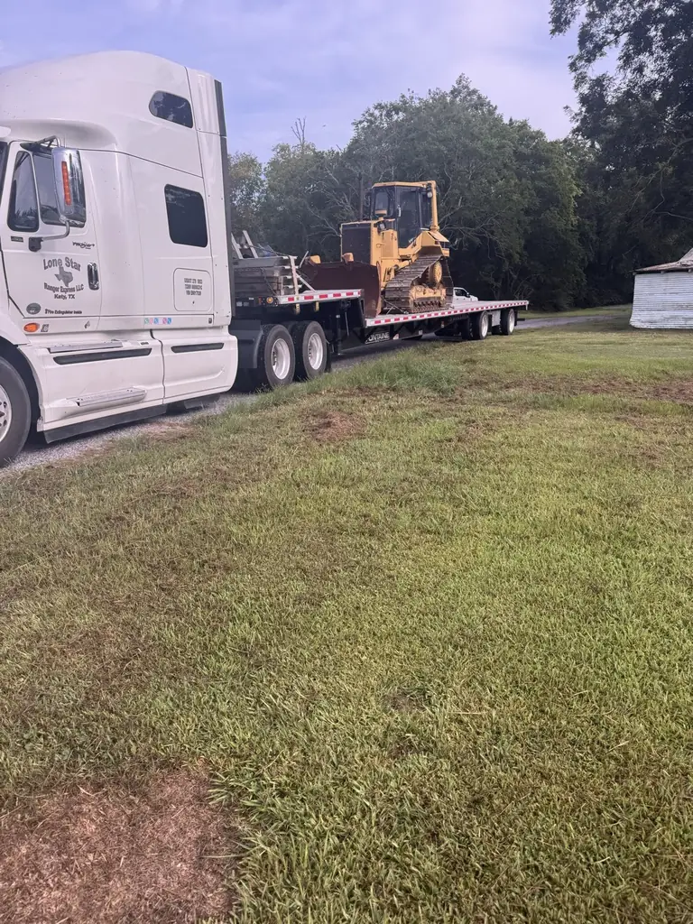 Dozer being offloaded from a lowboy trailer