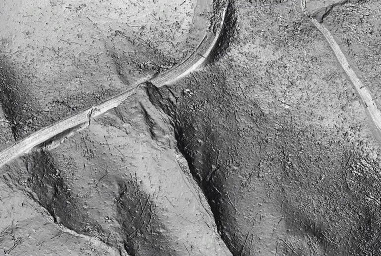 The same LiDAR point cloud with the tree points removed, showing the bare ground, the road cut and a slope failure